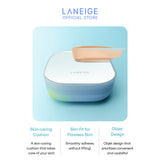 A pale beige swatch of Laneige Neo Cushion Mewy foundation is delicately swiped across the compact's mirrored surface, showcasing its smooth application and the product's ability to deliver a flawless, 24-hour complexion.