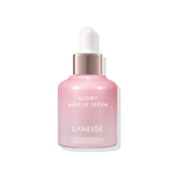 A bottle of Laneige Glowy Makeup Serum, a light pink serum with a rose gold dropper top, promises lightweight hydration for radiant, healthy-looking skin and long-lasting makeup.